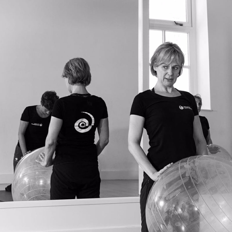 Pilates instructeur geeft persoonlijke begeleiding tijdens een les